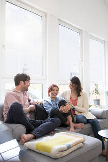 Glückliche Familie auf der Couch zu Hause - FKF03762