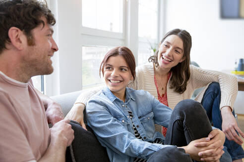 Glückliche Familie auf der Couch zu Hause - FKF03764