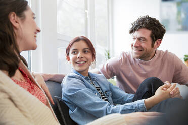 Glückliche Familie auf der Couch zu Hause - FKF03765