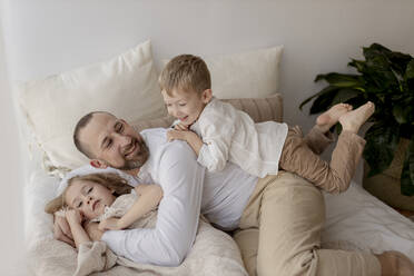 Familienporträt eines glücklichen Vaters und seiner beiden Kinder zu Hause - GMLF00131