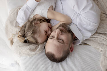 Vater und kleine Tochter ruhen zusammen auf dem Bett - GMLF00150