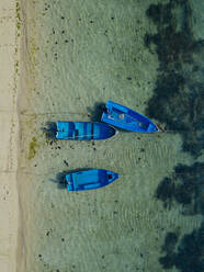 Indonesien, Bali, Sanur, Luftaufnahme von blauen Booten, die vor dem sandigen Küstenstrand vertäut sind - KNTF04572