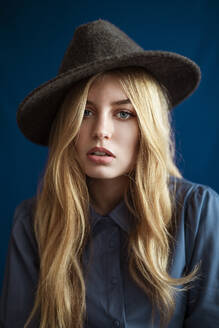 Portrait of blond woman wearing hat looking at camera - AGGF00062