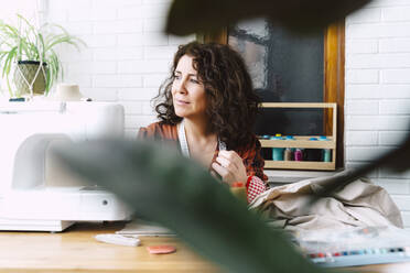 Portrait of woman sewing at home - ERRF03542