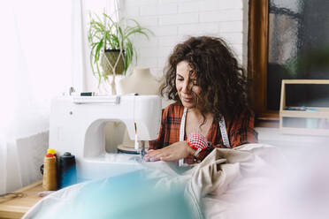 Woman sewing at home - ERRF03554