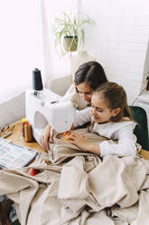 Two girls sewing at home - ERRF03569