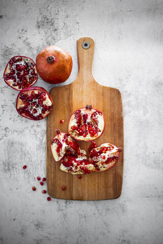 Quartered pomegranate on cutting board stock photo