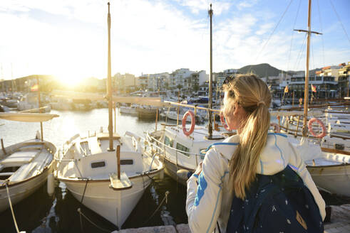 Frau genießt den Sonnenuntergang am Hafen, Port de Pollenca, Mallorca, Spanien - ECPF00896