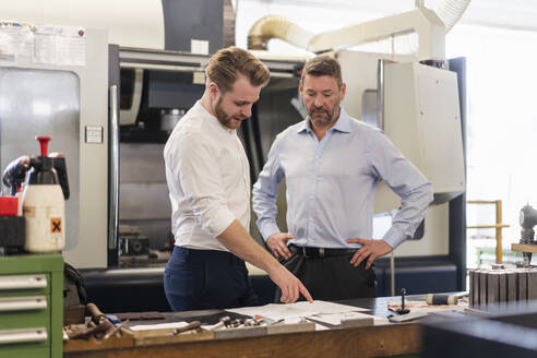 Zwei Geschäftsleute bei einer Arbeitsbesprechung in einer Fabrik - DIGF09999