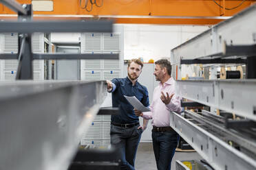 Zwei Männer besprechen einen Plan in einer Fabrik - DIGF10028