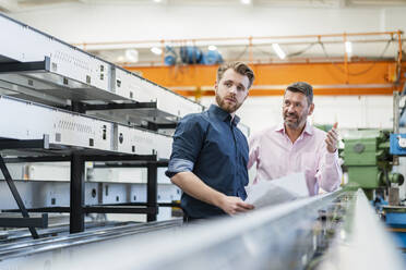 Zwei Männer bei einer Arbeitsbesprechung in einer Fabrik - DIGF10033