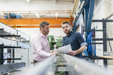 Zwei Männer bei einer Arbeitsbesprechung in einer Fabrik - DIGF10036