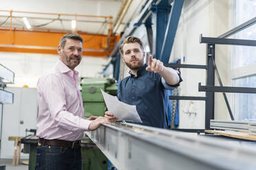 Zwei Männer bei einer Arbeitsbesprechung in einer Fabrik - DIGF10037