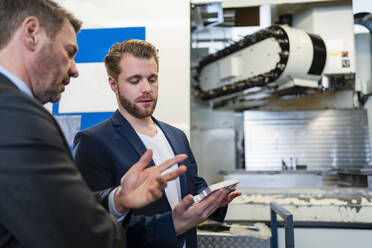 Two businessmen having a work meeting in a factory - DIGF10046