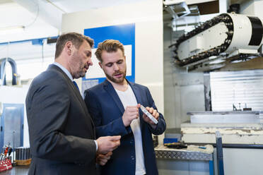 Two businessmen having a work meeting in a factory - DIGF10047