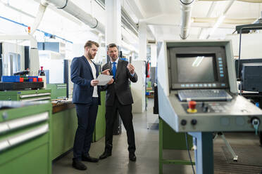 Two businessmen having a work meeting in a factory - DIGF10065