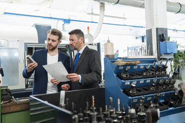 Two businessmen having a work meeting in a factory - DIGF10067