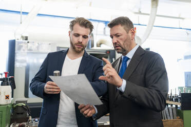 Zwei Geschäftsleute bei einer Arbeitsbesprechung in einer Fabrik - DIGF10069