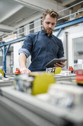 Young man using a tablet in a factory - DIGF10086