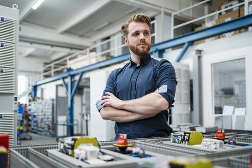 Porträt eines selbstbewussten jungen Mannes in einer Fabrik - DIGF10088