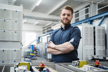 Porträt eines selbstbewussten jungen Mannes in einer Fabrik - DIGF10089