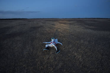 Raumfahrerin auf der Wiese liegend am Abend - VPIF02388