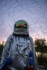 Portrait of spacewoman looking up at sunset - VPIF02402