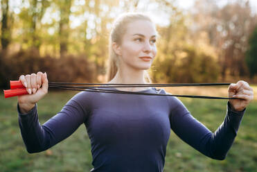 Training im Park, Mädchen hält ein Springseil. - CAVF80534