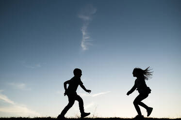 Silhouetted Children Running Together in Waco Texas - CAVF80568