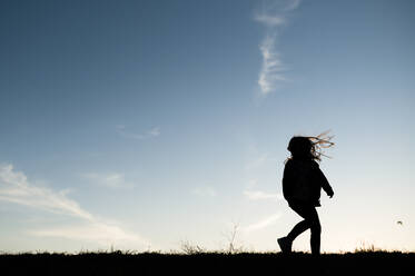 Silhouetted Girl Playing Running on Hill in Waco Texas - CAVF80569