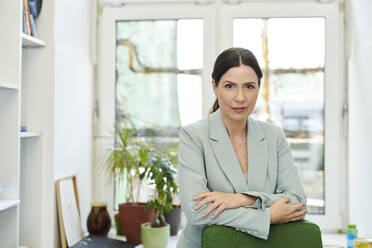 Portrait of confident mature businesswoman with arms crossed at office - MMIF00230