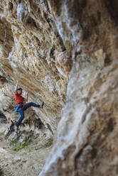 Ein Kletterer beginnt eine schwierige Route in einer Sportkletterhöhle. - CAVF80815
