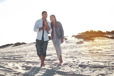 Young couple walking on sunny summer beach - CAIF26309