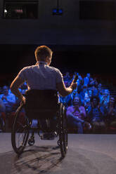 Sprecherin mit Mikrofon im Rollstuhl auf der Bühne - CAIF26348
