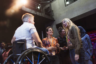 Frauen im Konferenzpublikum im Gespräch mit einem Redner im Rollstuhl - CAIF26356