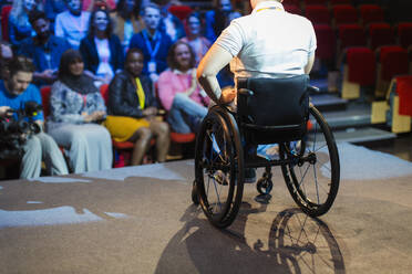 Publikum beobachtet Rednerin im Rollstuhl auf der Bühne - CAIF26360