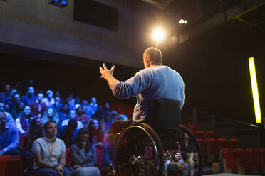 Publikum beobachtet männlichen Redner im Rollstuhl, der auf der Bühne spricht - CAIF26365