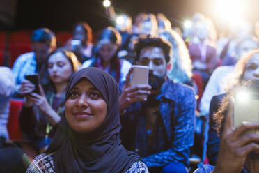 Lächelnde Frau im Hidschab hört im Publikum zu - CAIF26368