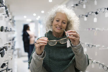 Ältere Frau kauft eine Brille in einem Optikergeschäft - CAIF26419