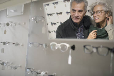 Senior couple shopping for eyeglasses in optometry shop - CAIF26422