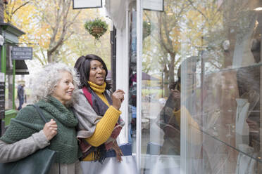 Senior women window shopping at urban storefront - CAIF26424