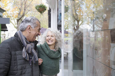 Senior couple window shopping at storefront - CAIF26425