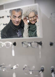 Senior couple shopping for eyeglasses in optometry shop - CAIF26427