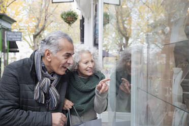 Senior couple window shopping at storefront - CAIF26429