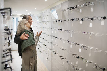 Senior couple shopping for eyeglasses in optometry shop - CAIF26431