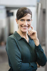 Portrait of a smiling businesswoman in a factory - DIGF10150