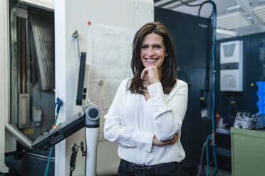 Portrait of a smiling businesswoman in a factory - DIGF10172