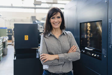 Portrait of a smiling businesswoman in a factory - DIGF10205