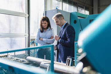 Businessman and businesswoman having a work meeting in a factory - DIGF10217