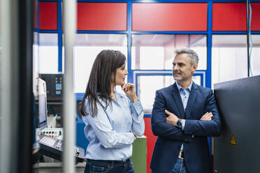 Businessman and businesswoman having a work meeting in a factory - DIGF10220